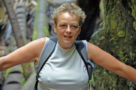 A tired tourist wandering in the mountains stopped to rest and looks at the lens with a smile.の写真素材