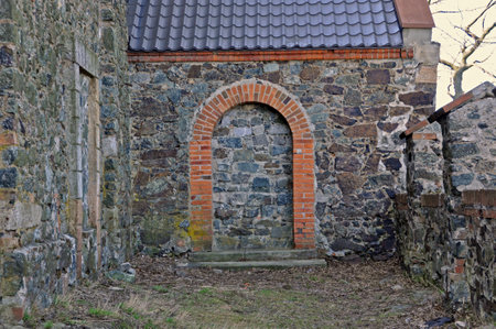 A fragment of a historic stone wall with a bricked-up entrance, marked with brickwork. ÅlÄÅ¼a, Lower Silesia, Poland.の写真素材