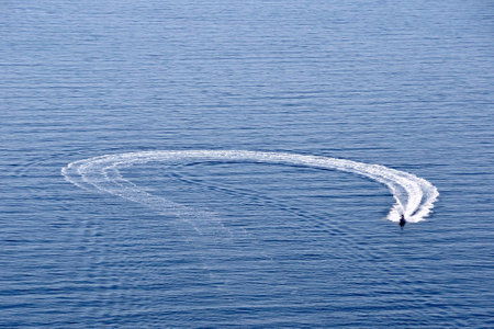 A motorboat on blue water flows over and over again.の写真素材