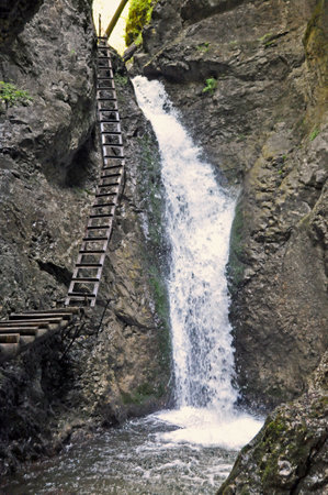 Waterfall in the Gorge Great Sokol in Slovak Paradise, with a steel ladder on a rocky wall.の写真素材