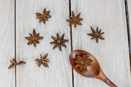 Star Anise on a Wooden Spoon on White Wooden Tableの写真素材
