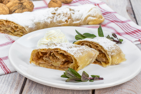 Two Slices Homemade Apple Strudel on Plate with Whipped Cream and Mintの写真素材