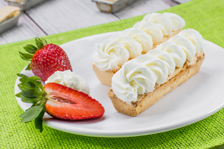 Strawberries and Sweet Traditional Czech Dessert - "Rakvi?ka se ?leha?kou" - Tiny Coffin with Whipped Cream on Green placematの写真素材