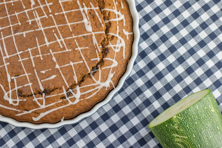 Detailed top View on Sweet gingerbread zucchini Pie with lemon topping on blue checkered placematsの写真素材