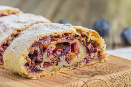 Detailed Front View on Plum strudel on wood plank timber on a old wooden boardの写真素材