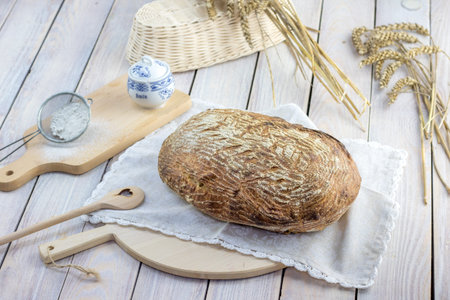 Caraway rye bread with rye flour, cob and heart spoon on white table