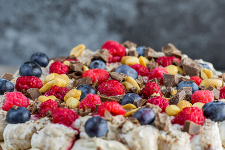 Detailed view on a peaches, chocolate, raspberries and blueberries on a cake with marble backgroundの写真素材