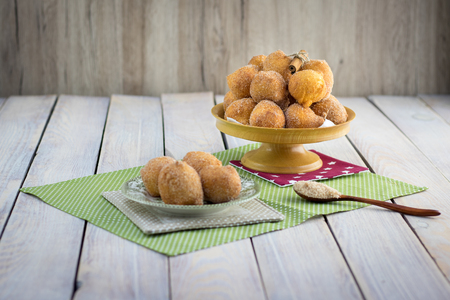 Fried curd donuts (marbles) in cinnamon sugar on a white tableの写真素材