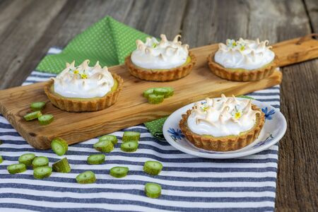 Tartlets with sour rhubarb filling and meringue on old wood tableの写真素材