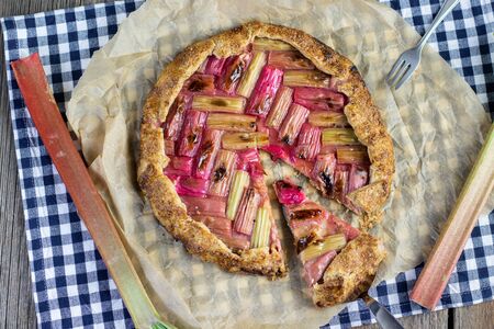 rustical rhubarb galette cake with slice on a confectionery shovel from aboveの写真素材