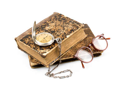 Old books on with glasses and pocket watch isolated on white backgroundの写真素材