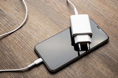 White charger lying on the phone.の写真素材