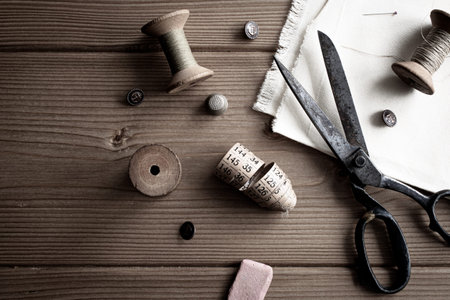 Vintage supplies and equipment for sewing on wooden background