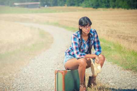 Beautiful brazilian woman with a suitcase on a road trip.の写真素材