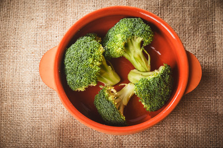 Broccoli in a bowl on a vintage wooden tableの写真素材