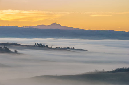 Fantastic Tuscan landscape in the fog and the light of the rising sun.の写真素材