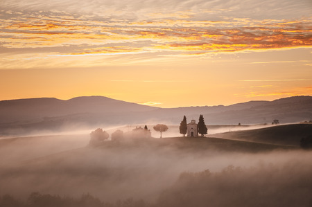 Sunrise over the chapel Vitaleta, beautiful landscape in the mist of Tuscany, Italy.の写真素材