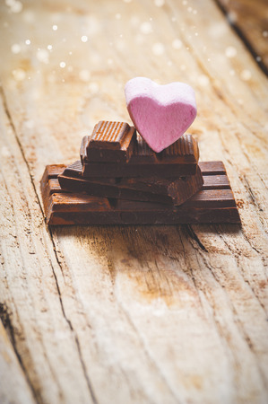 Pink heart on a black chocolate with rustic wooden backgroundの写真素材