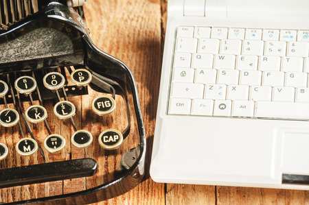 Closeup of a modern laptop computer and an antique typewriterの写真素材