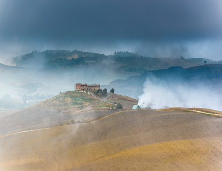 Beautiful foggy landscape in the middle sunrise. Italy, Tuscany.の写真素材