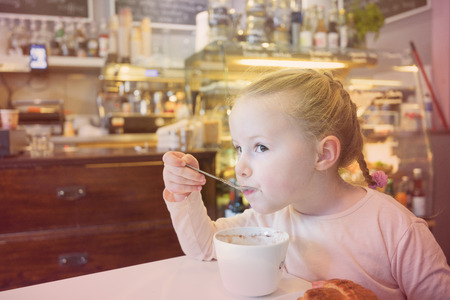 Beautiful young girl at the bar eating breakfast.の写真素材