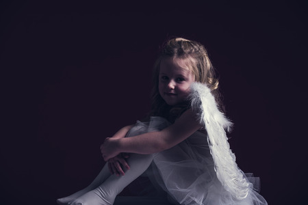 Beautiful blond hair angel on a red backgroundの写真素材