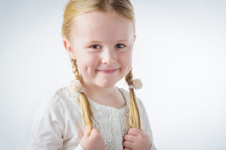 Smiling little blond girl with pigtailsの写真素材