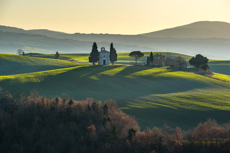 Sunrise over the fields and chapel winter morningの写真素材