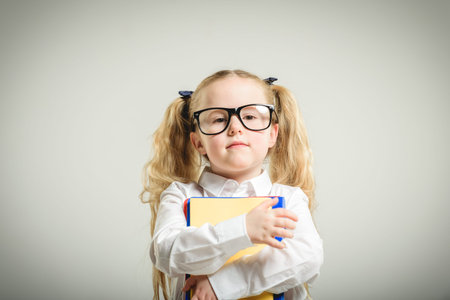 Schoolgirl in glasses reaching toward the school.