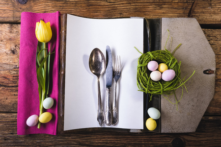 Easter menu on a wooden table decorated in eggs and fresh flowers.の写真素材