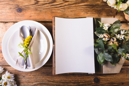 Easter menu on a wooden table decorated in eggs and fresh flowers.の写真素材