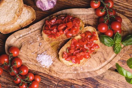 Italian bruschetta, toasted bred with fresh tomato and basil on woody vintage tableの写真素材