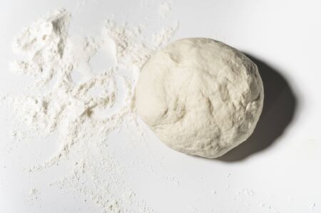 Crushed and prepared pizza dough, cake, bread on the tableの写真素材