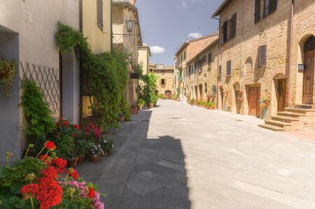 Sunny streets with colorful flowers with contrasting shades. Walk the Tuscan townの写真素材
