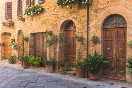 Sunny streets with colorful flowers with contrasting shades. Walk the Tuscan townの写真素材