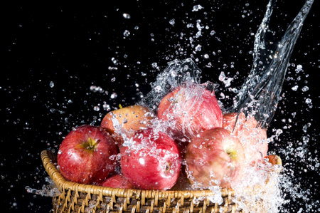 Apple and splashing water on black backgroundの写真素材