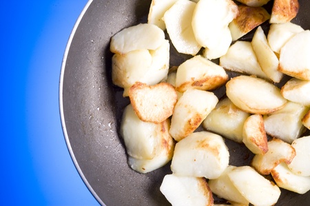 Fried potatoes in frying-pan isolated on blue
の写真素材