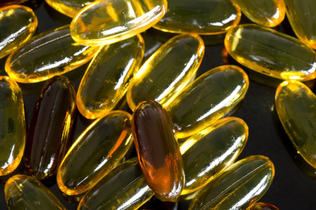 Yellow capsule  on black background. Healthcare and medicine