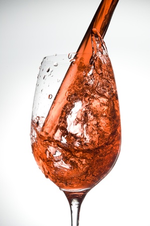 Red wine being poured intro glass isolatet on white
の写真素材