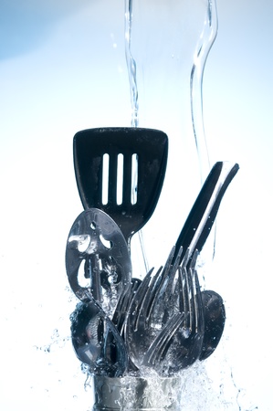 Washing kitchen ware in clear water on blue background
の写真素材