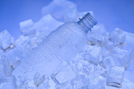 Mineral water with ice. Blue background with plastic bottleの写真素材