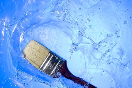 Paintbrush falling on the blue water. Creative splashingの写真素材