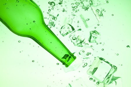 Green bottle with creative splashing green waterの写真素材