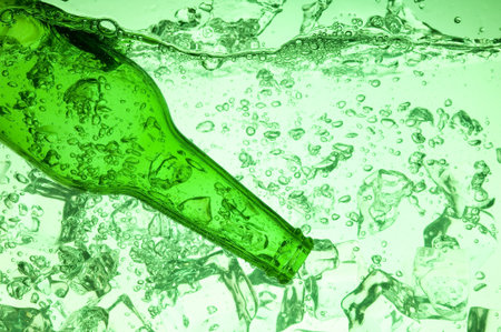 Green bottle with creative splashing green waterの写真素材