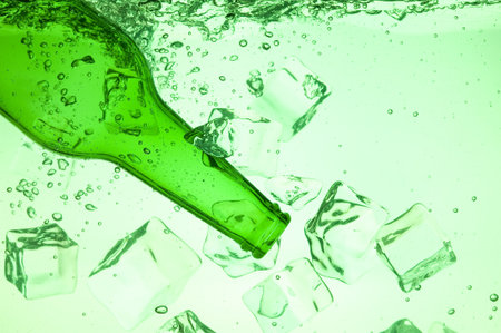 Green bottle with creative splashing green waterの写真素材