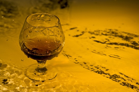 Class of brandy on creative brown background with waterの写真素材