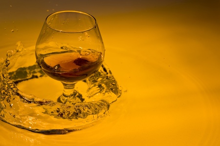 Class of brandy on creative brown background with waterの写真素材
