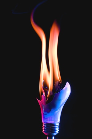 Broken light bulb with smoke on black backgroundの写真素材