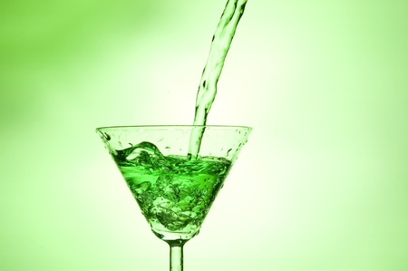 Splashing green cocktail in martiniglassの写真素材