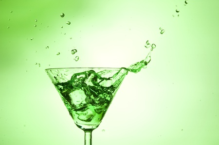 Splashing green cocktail in martiniglassの写真素材